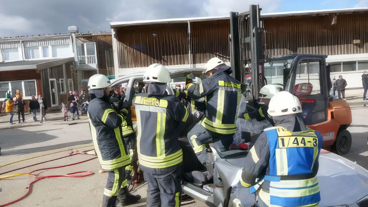 Die Einsatzkräfte erleichtern die Rettung des schwer verletzten Fahrers, indem sie das abgeschnittene Dach des Pkws vorsichtig entfernen.