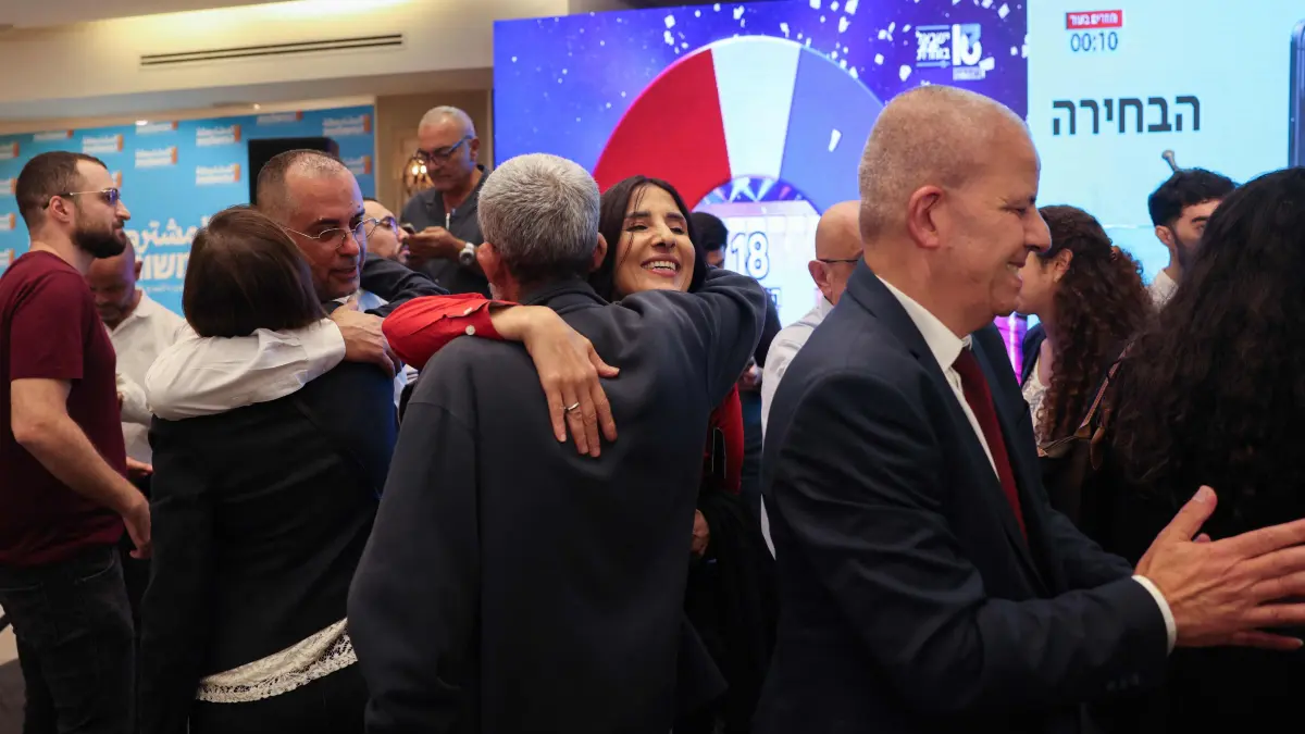 ISRAEL-VOTE: Supporters of Israel's Arab-led Joint List political alliance celebrate at the alliance's campaign headquarters in the northern Israeli city of Nazareth on October 27, 2026, as the first exit polls are announced on television during Israel's legislative election. Israeli voters on October 27 gave a narrow edge to opposition parties over Prime Minister Benjamin Netanyahu, initial projections showed, after decades-high turnout in the country's first election since the trauma of the October 7, 2023 attacks. (Photo by AHMAD GHARABLI / AFP)