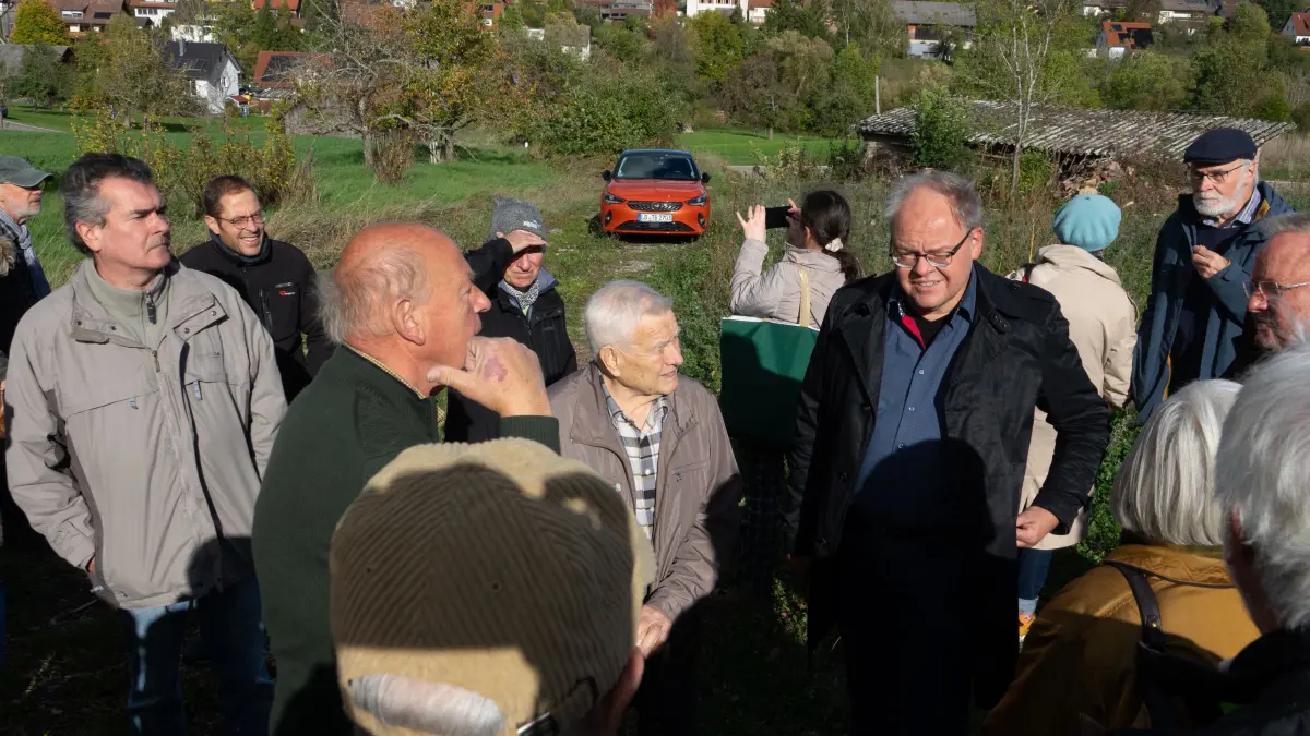 : Eine Gruppe Interessierter vor Ort auf dem Gelände des ehemaligen Steinbruchs. Dr. Rupert Wild in der grauen Jacke, rechts daneben mit Brille Prof. Schoch.