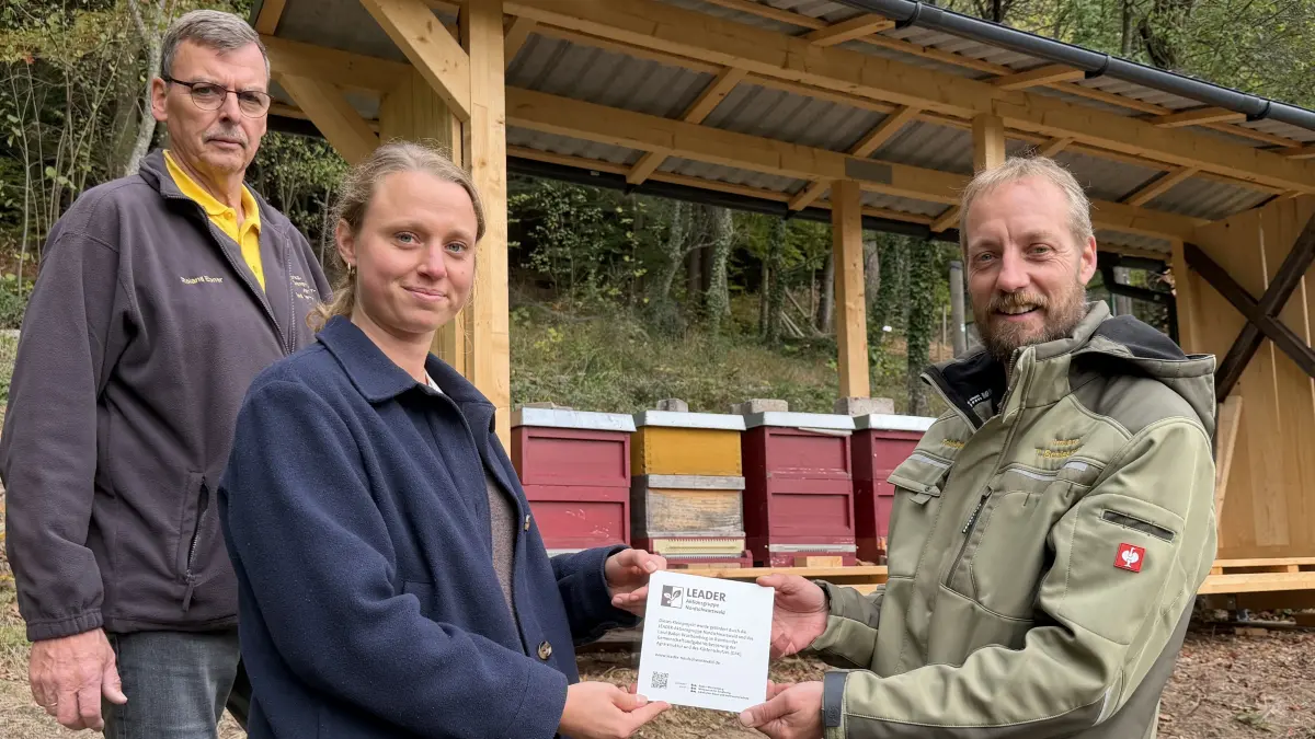 Überreichung der Leader-Plakette für die Erlebnisimkerei (von links): Roland Ebner, Vorsitzender des Bienenzüchtervereins Bad Herrenalb, Caroline Bauer, Aktionsgruppe Leader Nordschwarzwald, Torsten Schiebenes, Imker und Gestalter der Erlebnisimkerei.