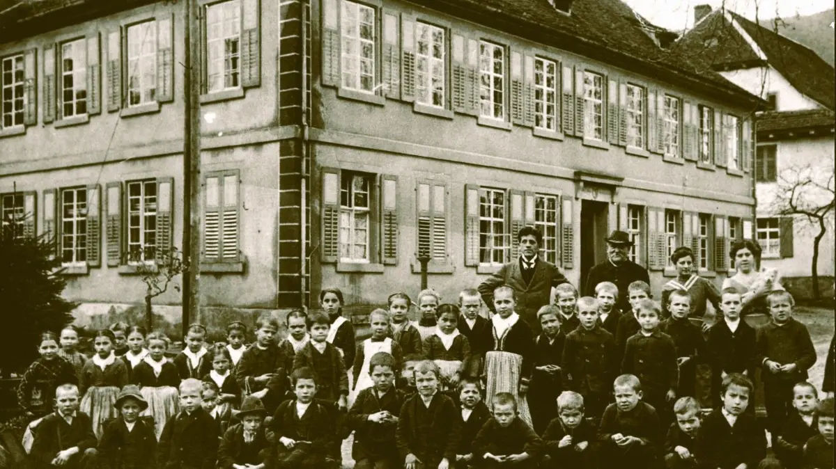 Reichtum an Kindern und das Nichtvorhandensein an weiterführenden Schulen sorgte auch in Oberwolfach für gut besuchte Volksschulen wie hier um 1912 im Ortsteil Kirche mit dem Schulleiter Wilhelm Eitel – mit Hut! Es sind hier wohl lediglich die Schüler der Mittelstufe mit den Klassen vier bis sechs zum Fotografieren aufgestellt.