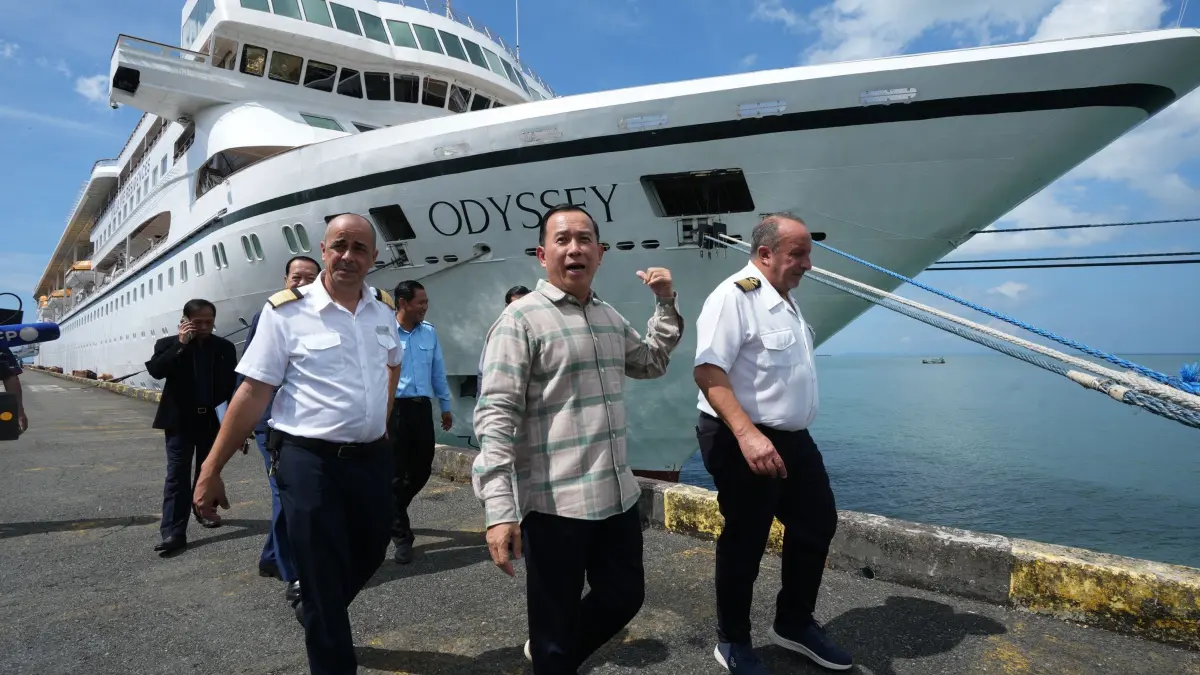 US-Kreuzfahrtschiff in Kambodscha: Der kambodschanische Tourismusminister Huot Hak (M) geht in Sihanoukville, Kambodscha, gemeinsam mit den Kapitänen des US-Kreuzfahrtschiffs „MV Odyssey Emanuele Giudice“ (r) und Rodrigo (l) in der Nähe des Kreuzfahrtschiffs spazieren. (zu dpa: «Kreuzfahrt-Aus in Kambodscha sorgt weltweit für Aufsehen»)