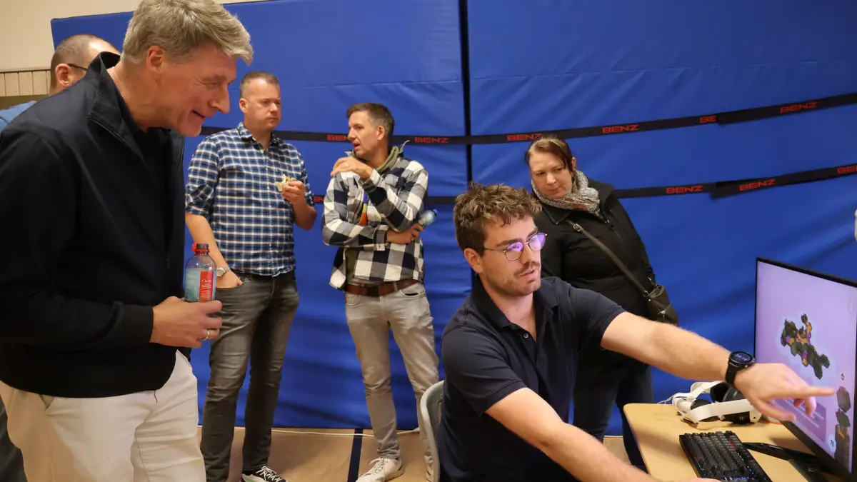Der Rektor der Südstadtschule, Elmar Dressel, ließ sich vom Schiller-LAN-Mitglied Vincent Wilke (vorn, Mitte) das Computerspiel „Dorfromantik“ erklären.
